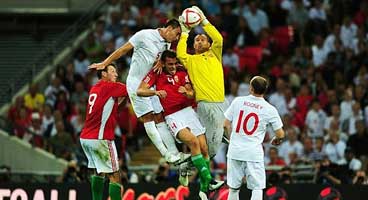 Király plukt de bal vóór John Terry.