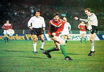 Róth beschermt zich bij een schot van Karl-Heinz Rumenigge tijdens een interland tegen Duitsland.
