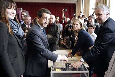 Nicolas Sarkozy, samen met zijn vrouw Carla Bruni, nog hoopvol in het stemlokaal...